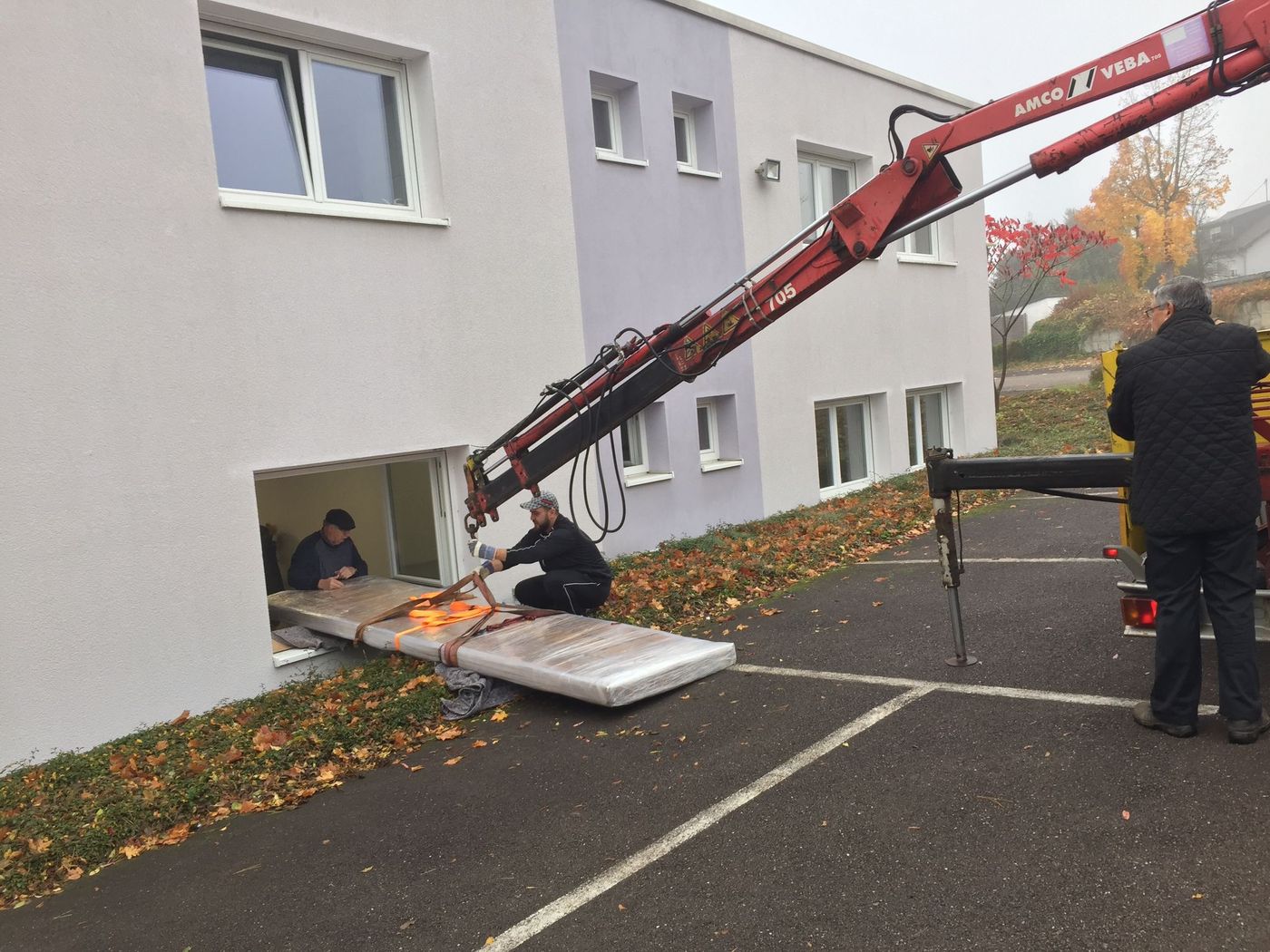 Kraneinsatz: eine massive Tischplatte wird durch ein Fenster gehoben